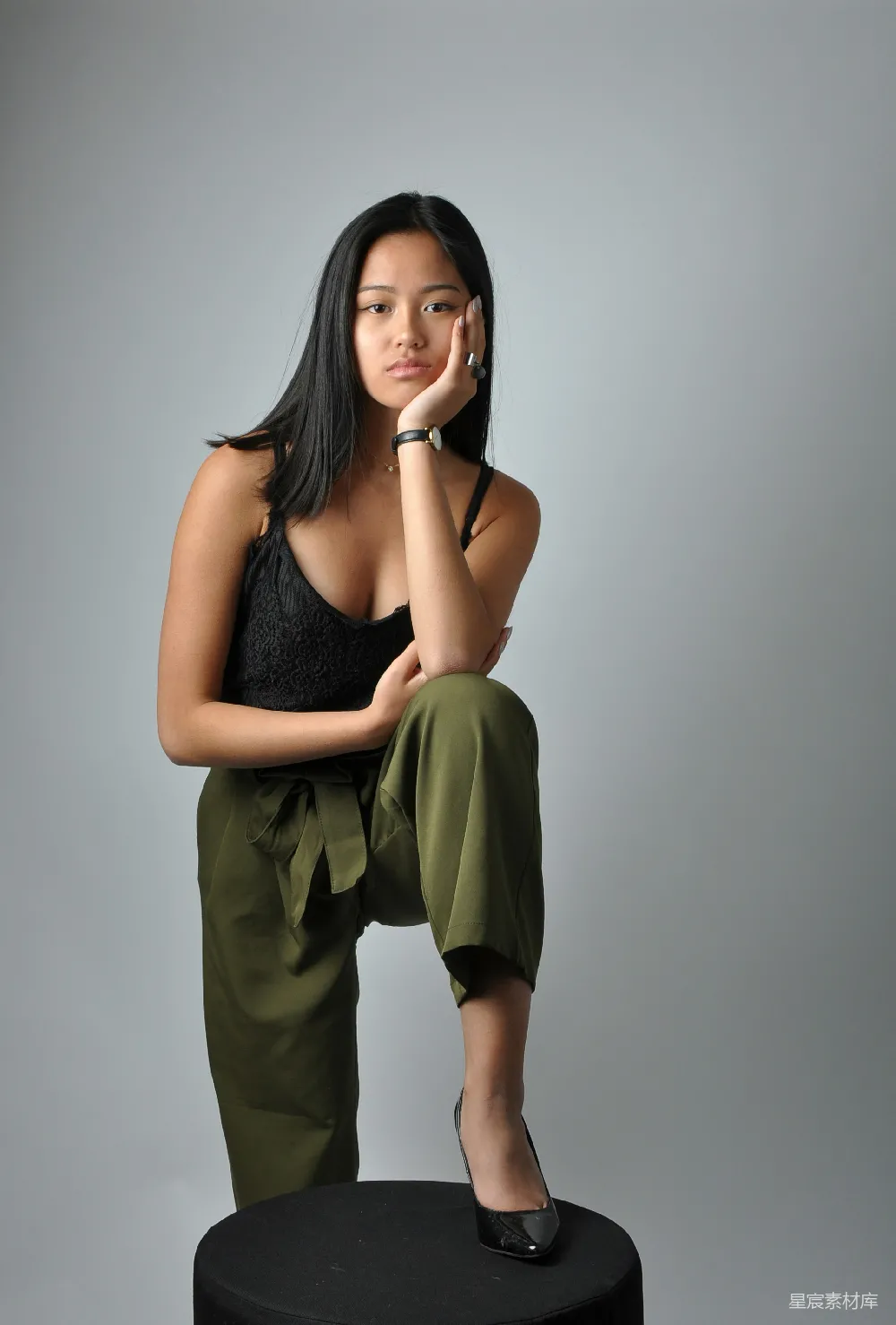 高清摄影 一个女人坐在黑色的小凳子上。