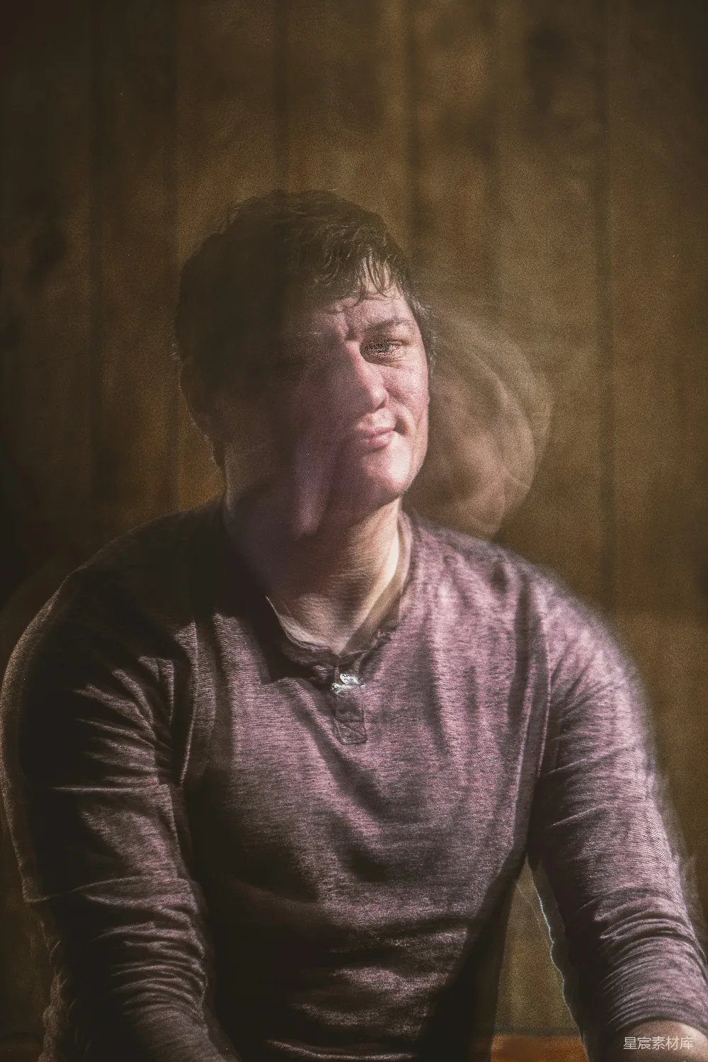 高清摄影 人物 一个男人坐在一张木制墙壁前面抽着香烟。