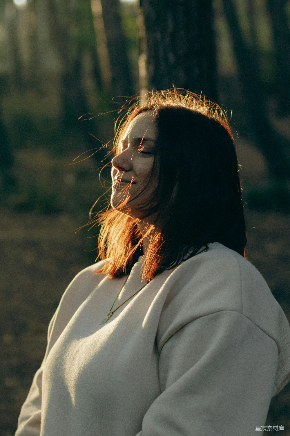 高清摄影  一个女人站在树林中，脸上涂着彩妆。
