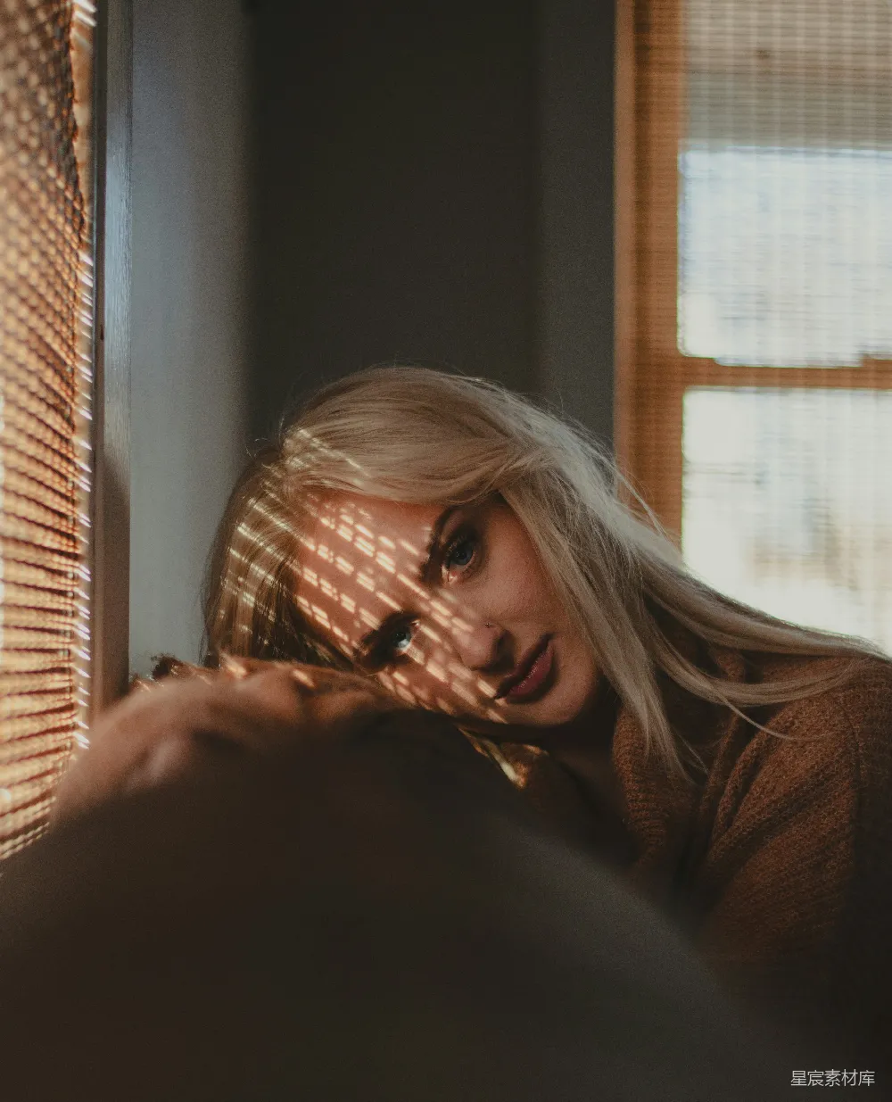 高清摄影 一个留着金色头发的女人正在窗边眺望。