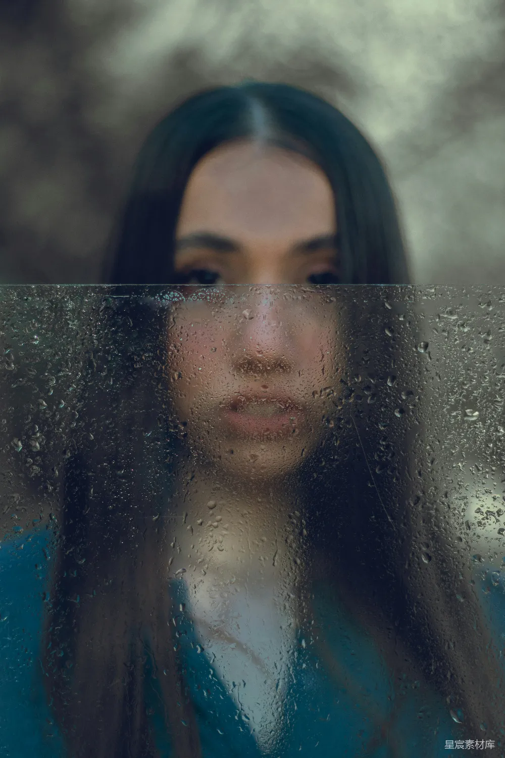 高清摄影 一个女子透过蒙上雨的窗户看外面。