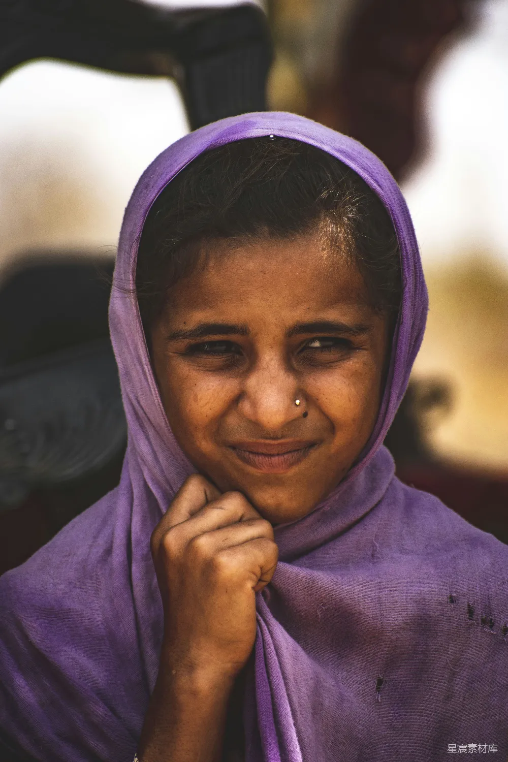 高清摄影 一个穿着紫色围巾的年轻女孩对着相机微笑。