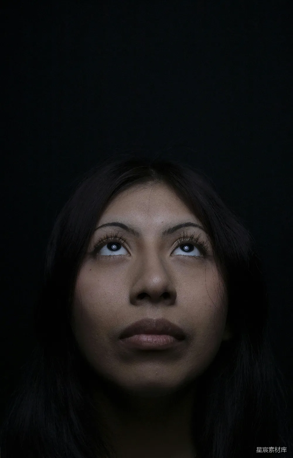 高清摄影 女人仰头望着，背景为暗色。