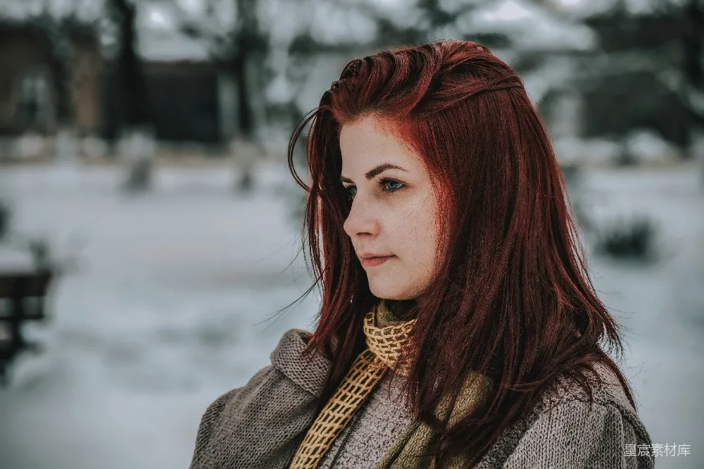 高清摄影  一个红发的女人正站在雪地里。