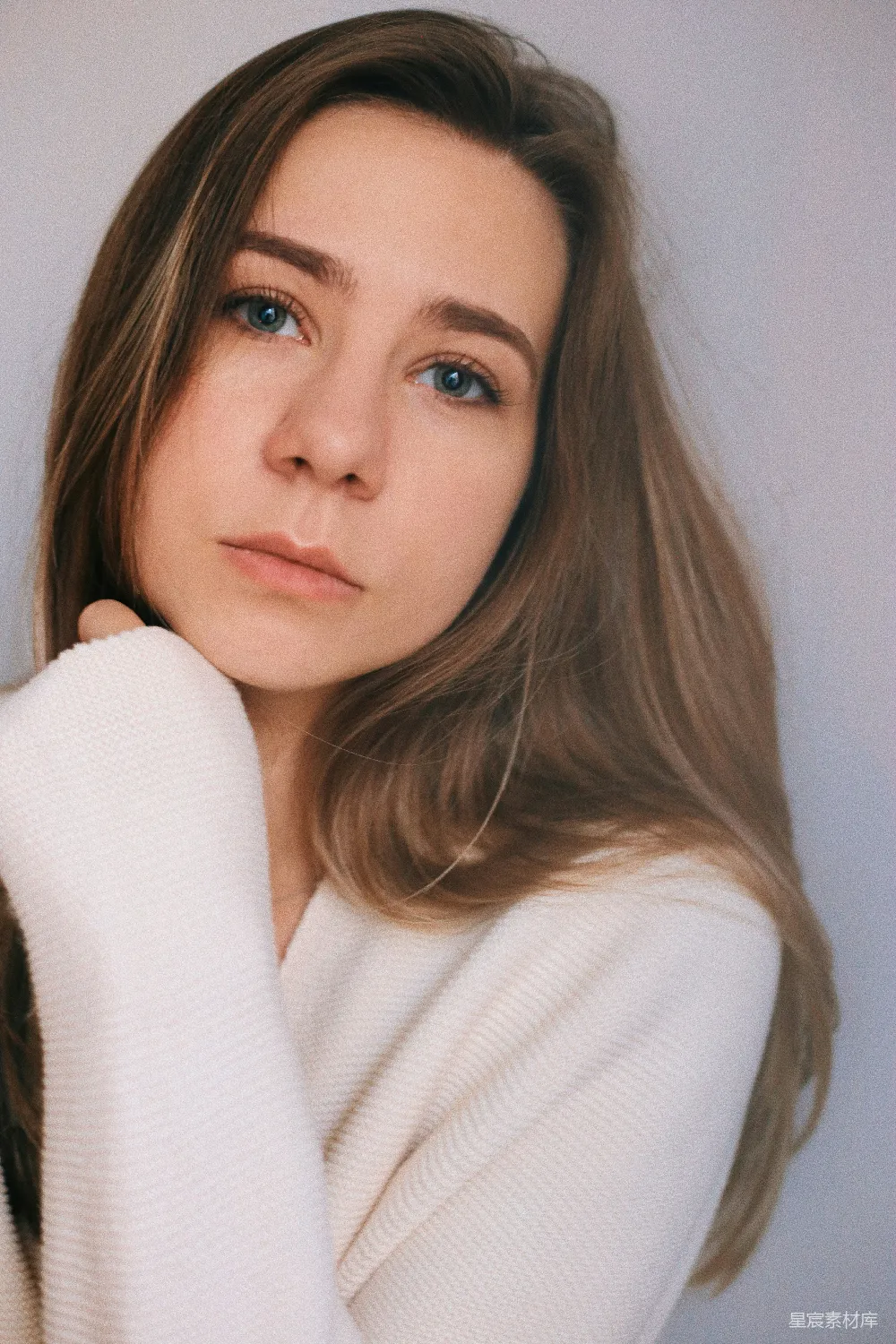 高清摄影 一个穿白色毛衣的女人在拍照。