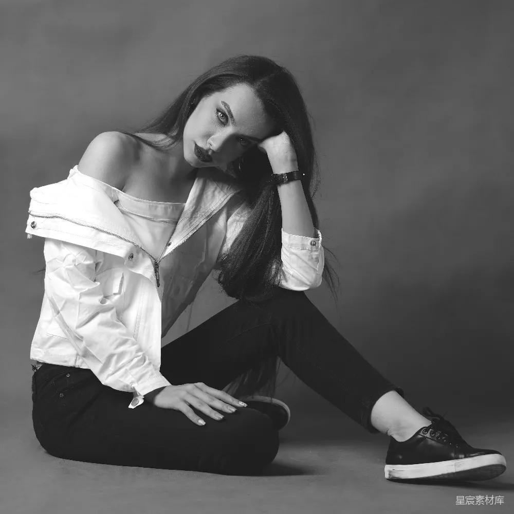 高清摄影 白上衣着装的女性坐在地板上，穿着黑色长裤