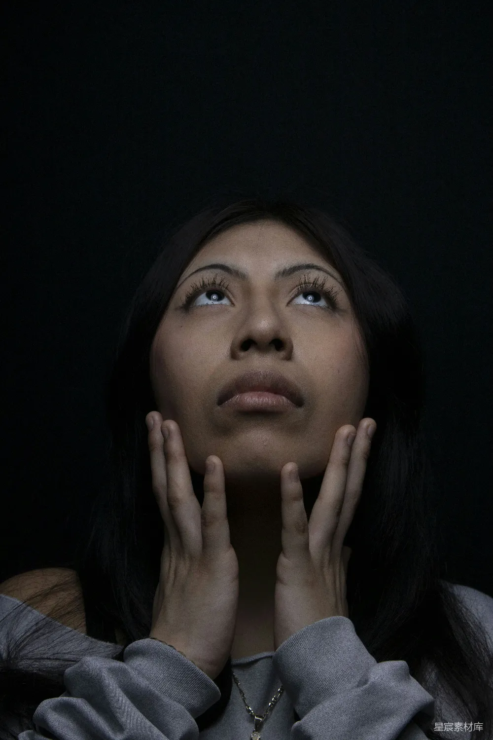 高清摄影 女人仰头看，双手接近她的脸。
