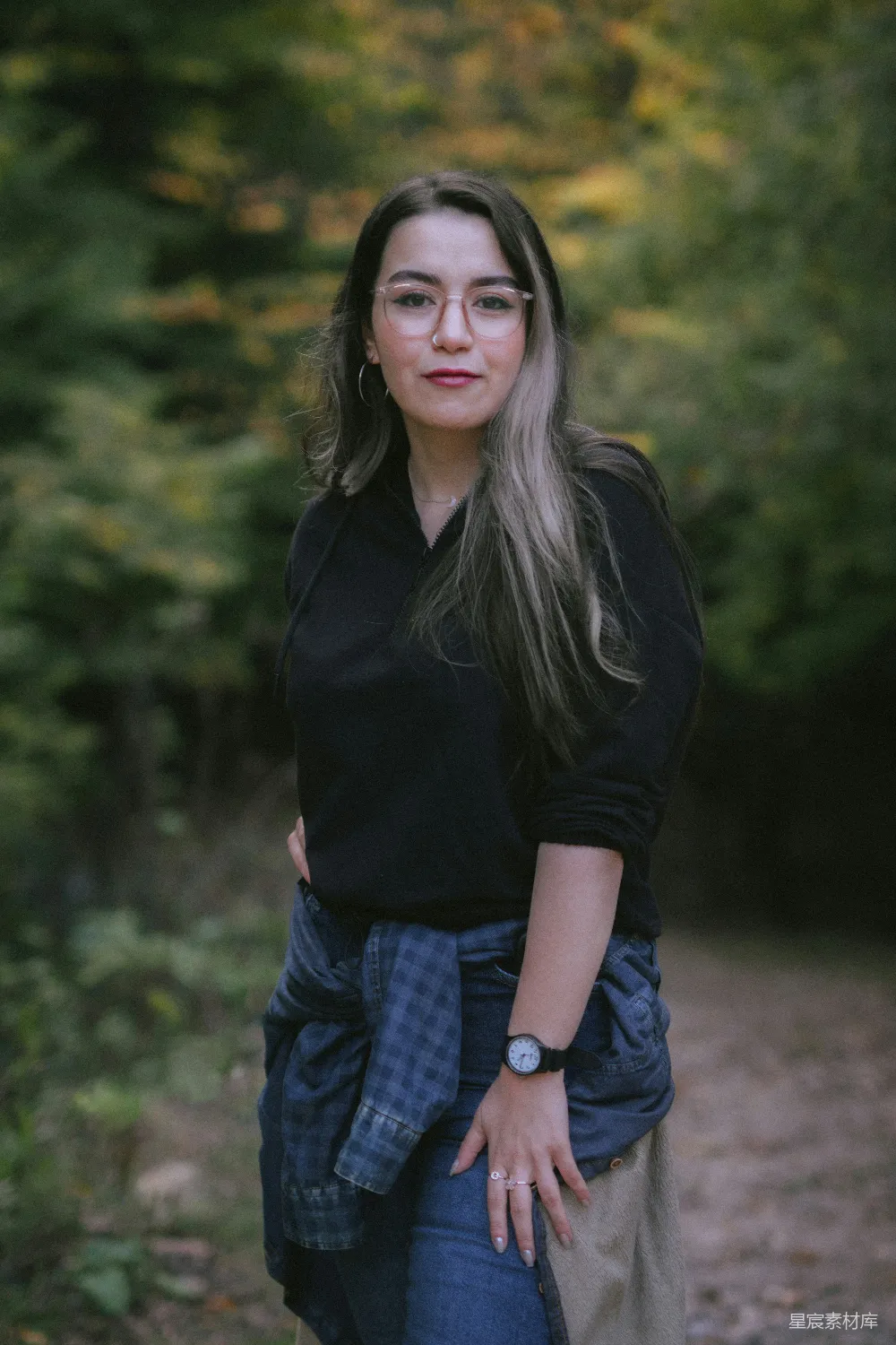 高清摄影 一个女人站在树林里，双手叉腰。