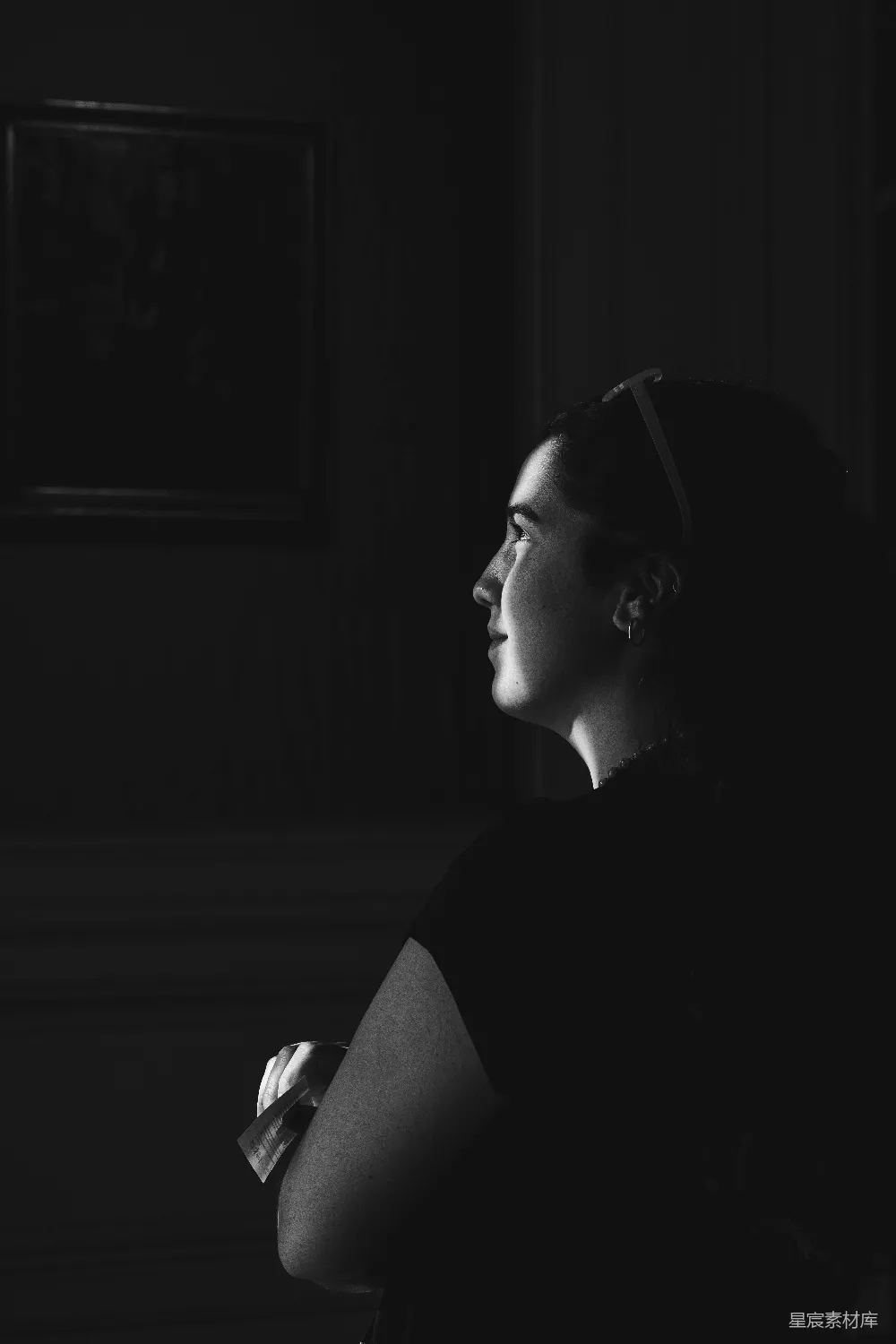 高清摄影 一位妇女在黑暗中仰望，眼神中充满了希望。