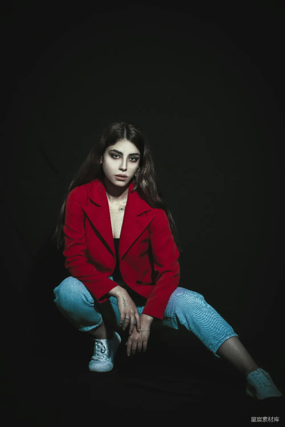 高清摄影  一个穿着红色夹克的女人坐在黑色背景上