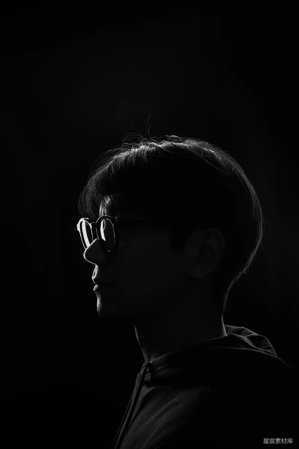 高清摄影 一个戴着眼镜和卫衣的人在黑暗中