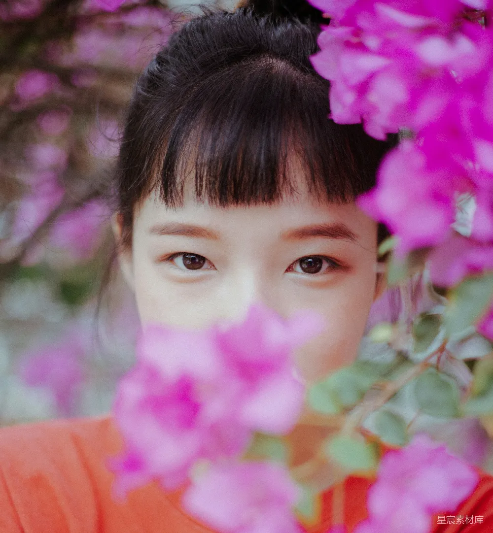 高清摄影 一个头发扎成马尾的女孩，头发上插着粉色的花。