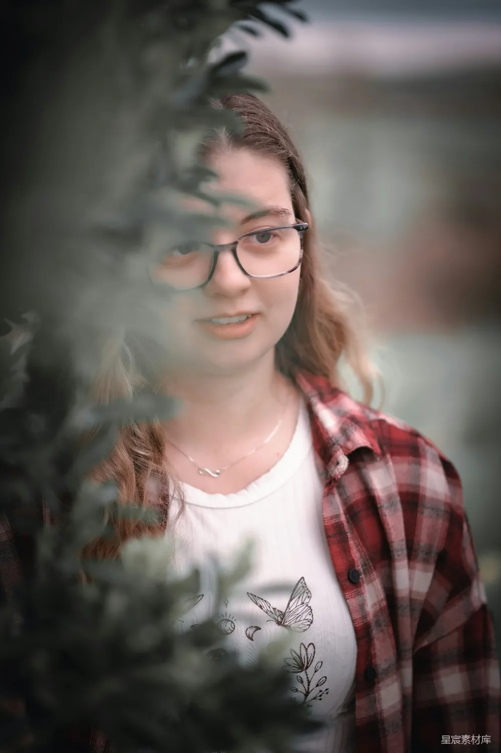 高清摄影 戴眼镜的女人在树丛中张望。