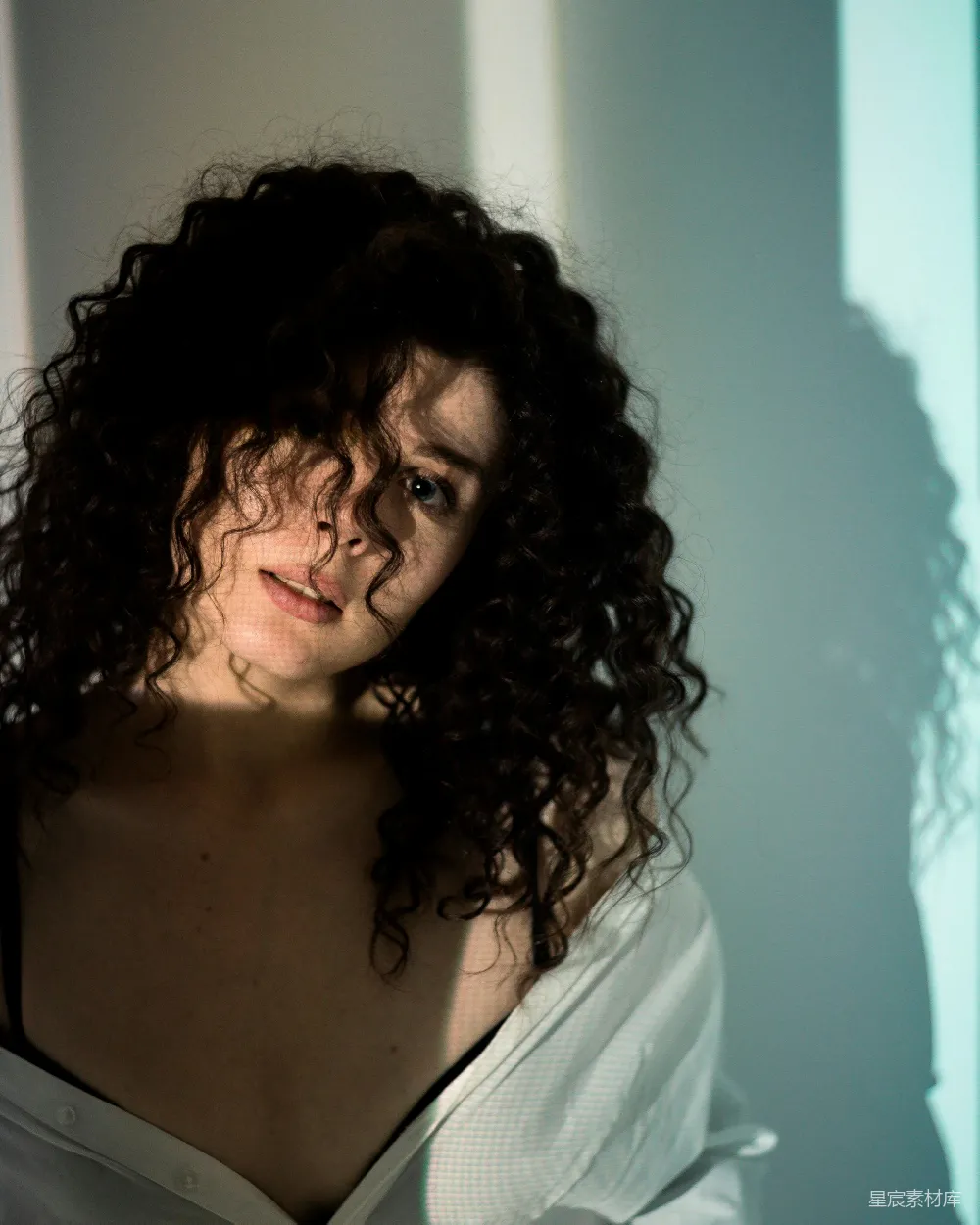 高清摄影 一头 curly 发型的女士在拍照。