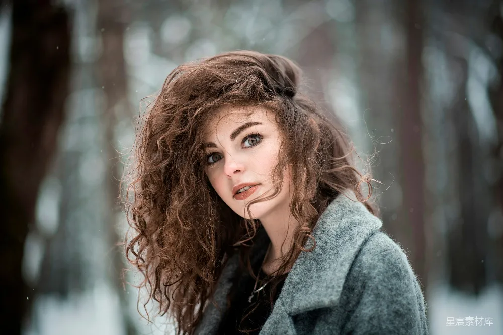 高清摄影 一头 curly 头发的女人站在雪中