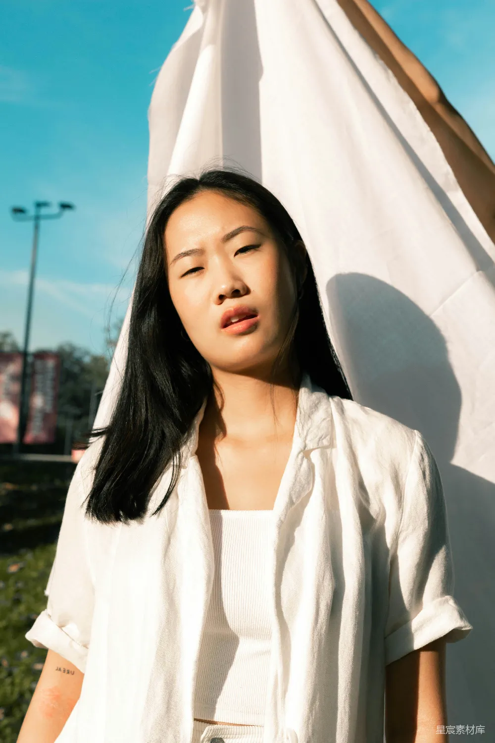 高清摄影 白裙女子站在白帐篷附近，白天站立。
