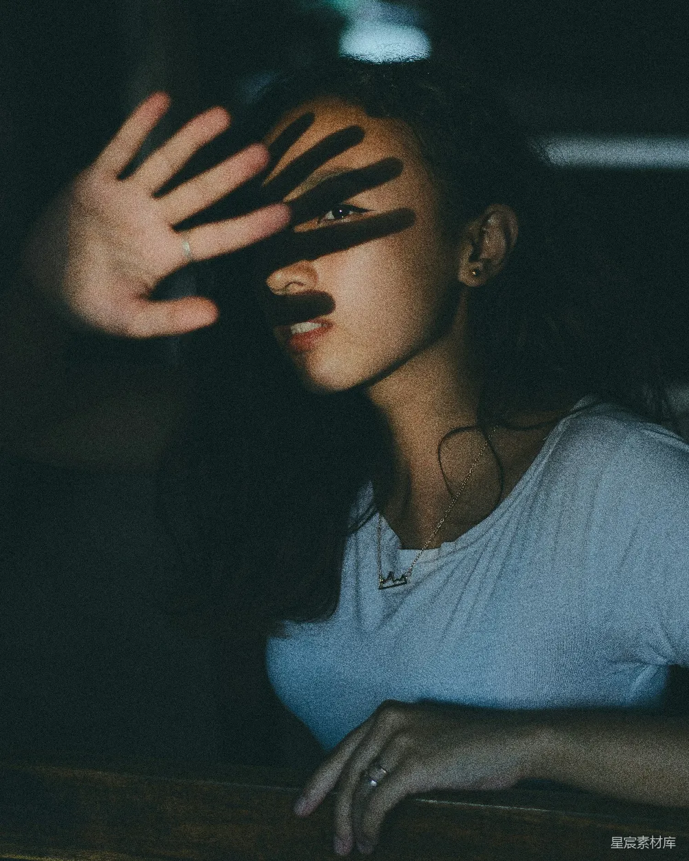 高清摄影  白色v领上衣穿着者在黑暗房间内