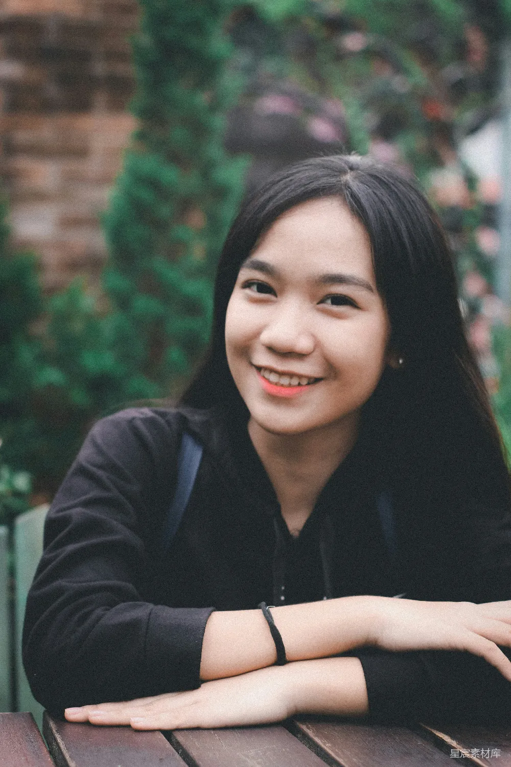 高清摄影 一位女人坐在桌子旁，双手交叉。