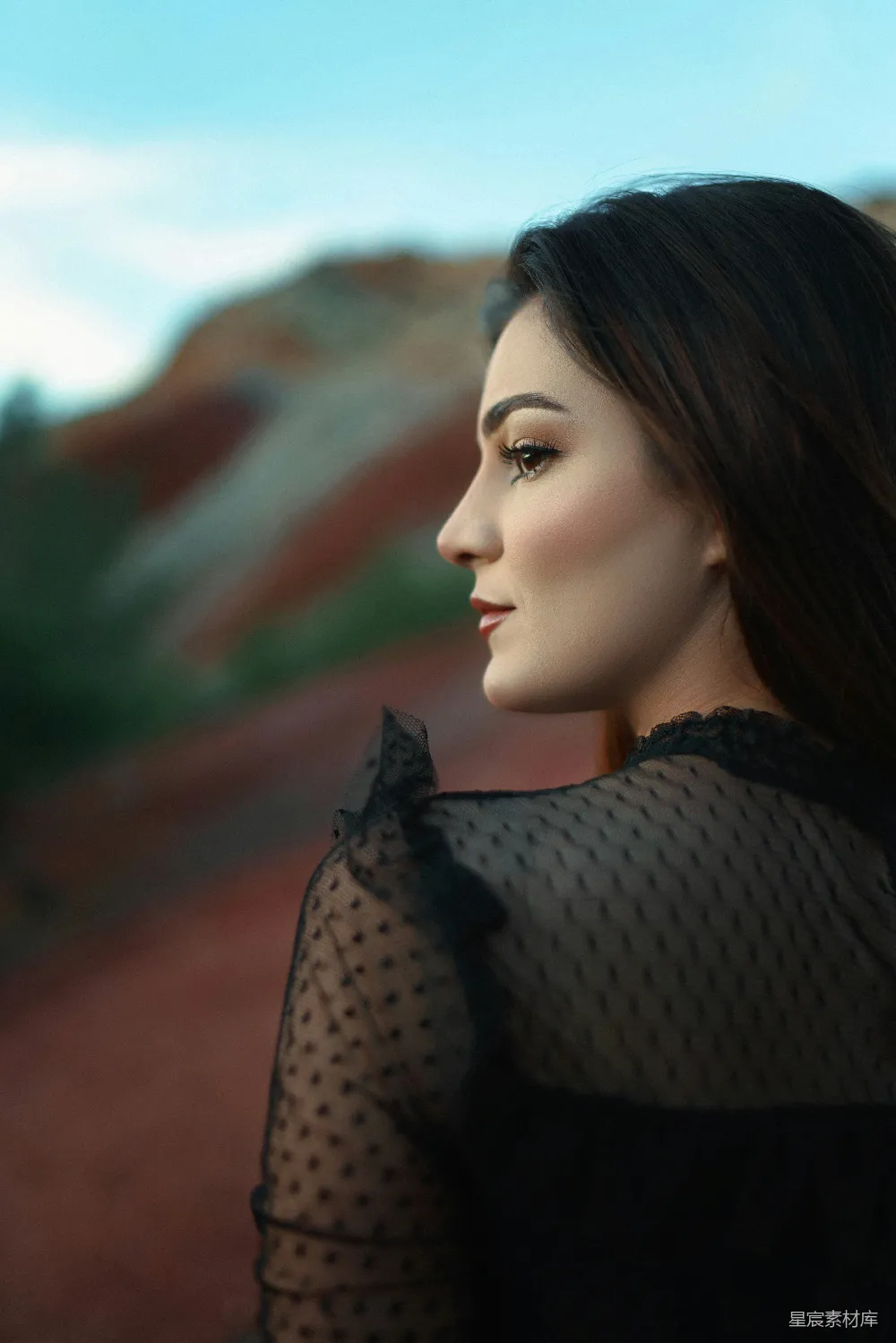 高清摄影  一张女人近照，背景是山峦。