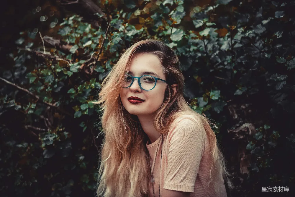 高清摄影  女人站在一旁的绿色灌木丛旁