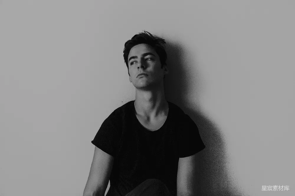 高清摄影  墙边 leaning 的男人的黑白摄影