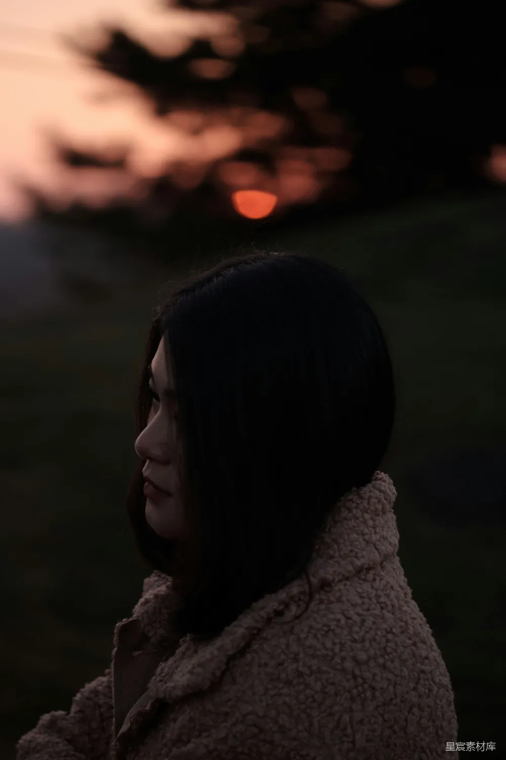 高清摄影 穿着棕色夹克的女孩正在户外金光闪耀时站立着。