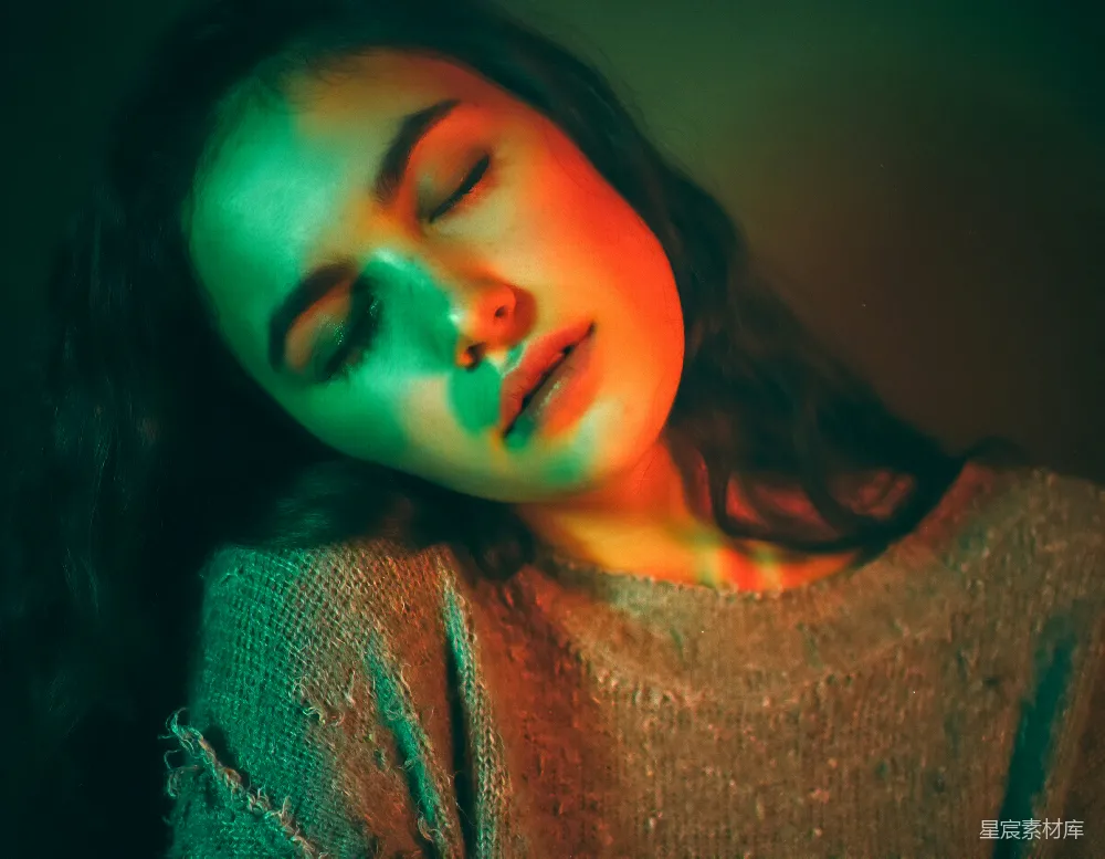 高清摄影  闭眼的女性被绿色和红色的灯光照亮