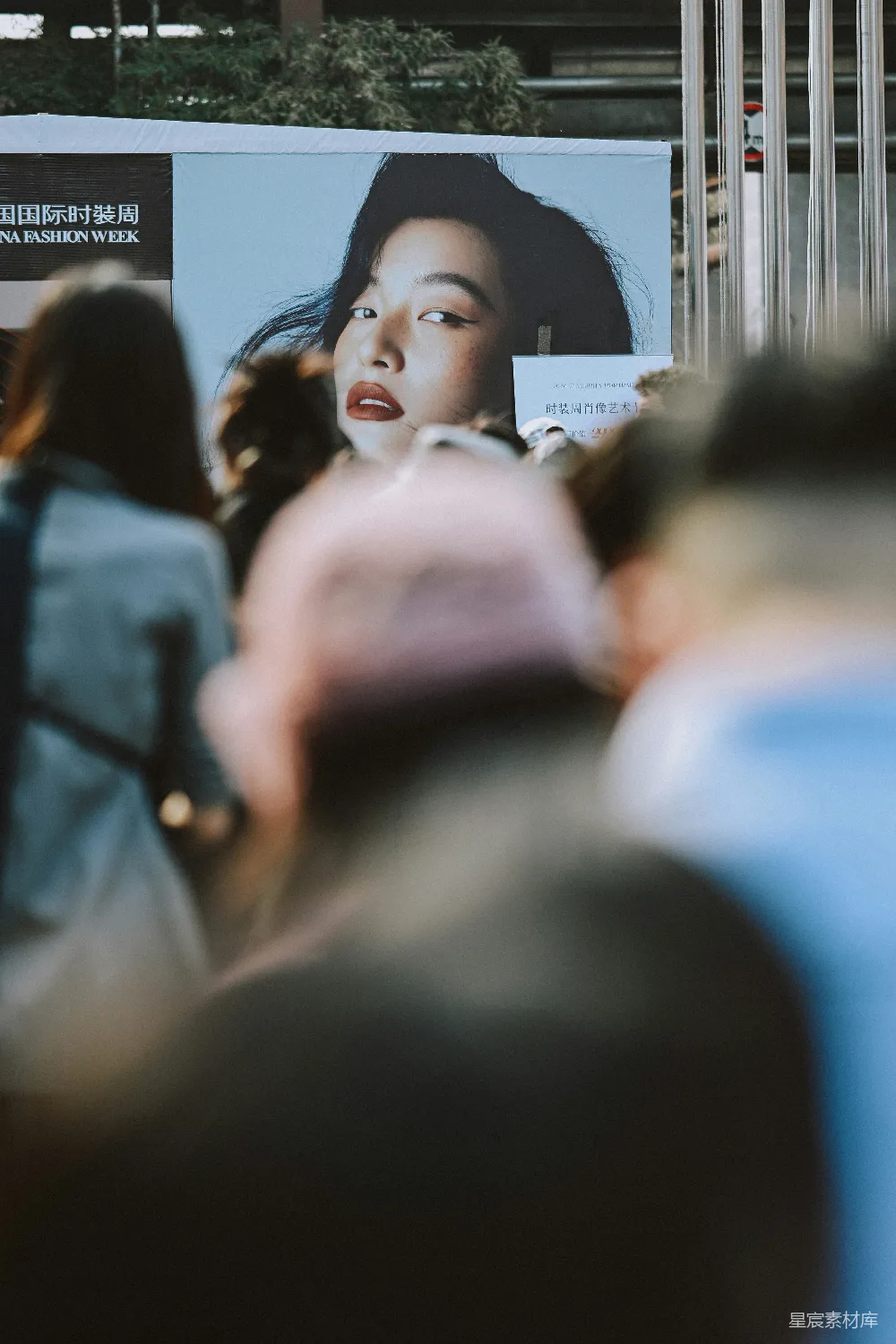 高清摄影 billboard上女人的脸， foreground中有一群人。