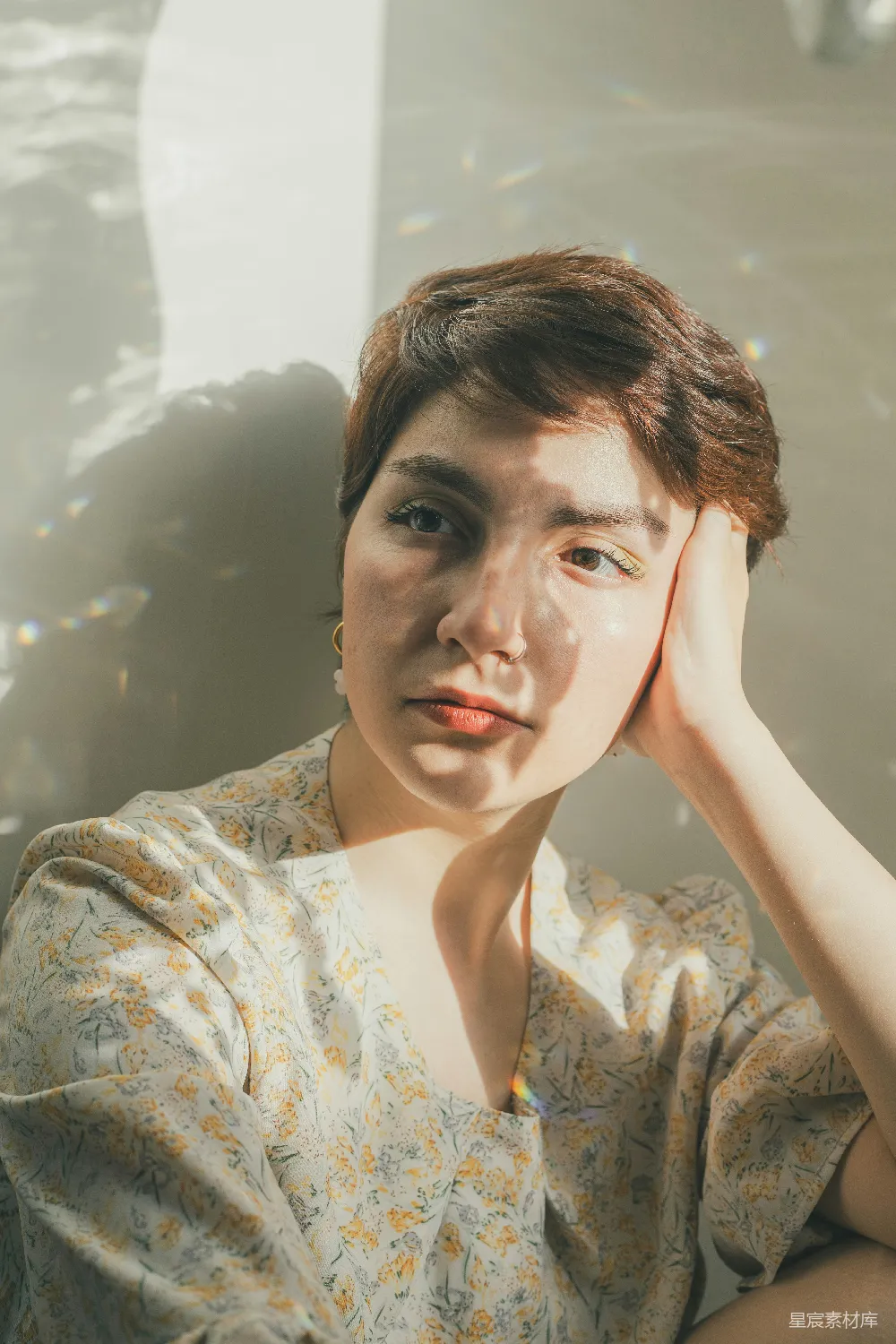 高清摄影 一个带着短棕色头发的年轻女子倚着头。