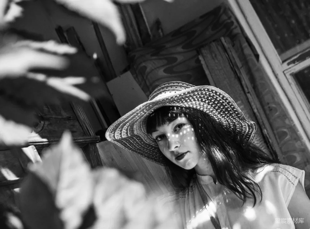高清摄影  一个戴帽子的妇女站在窗户前