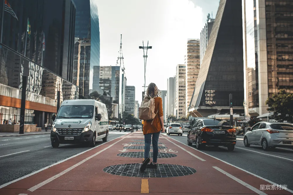 高清摄影 自然 女性在道路上行走，道路两旁有车辆的摄影作品