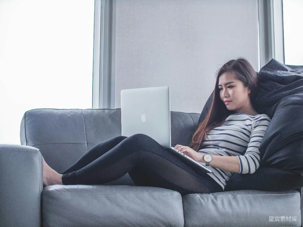 高清摄影  女人坐在沙发上使用MacBook Pro