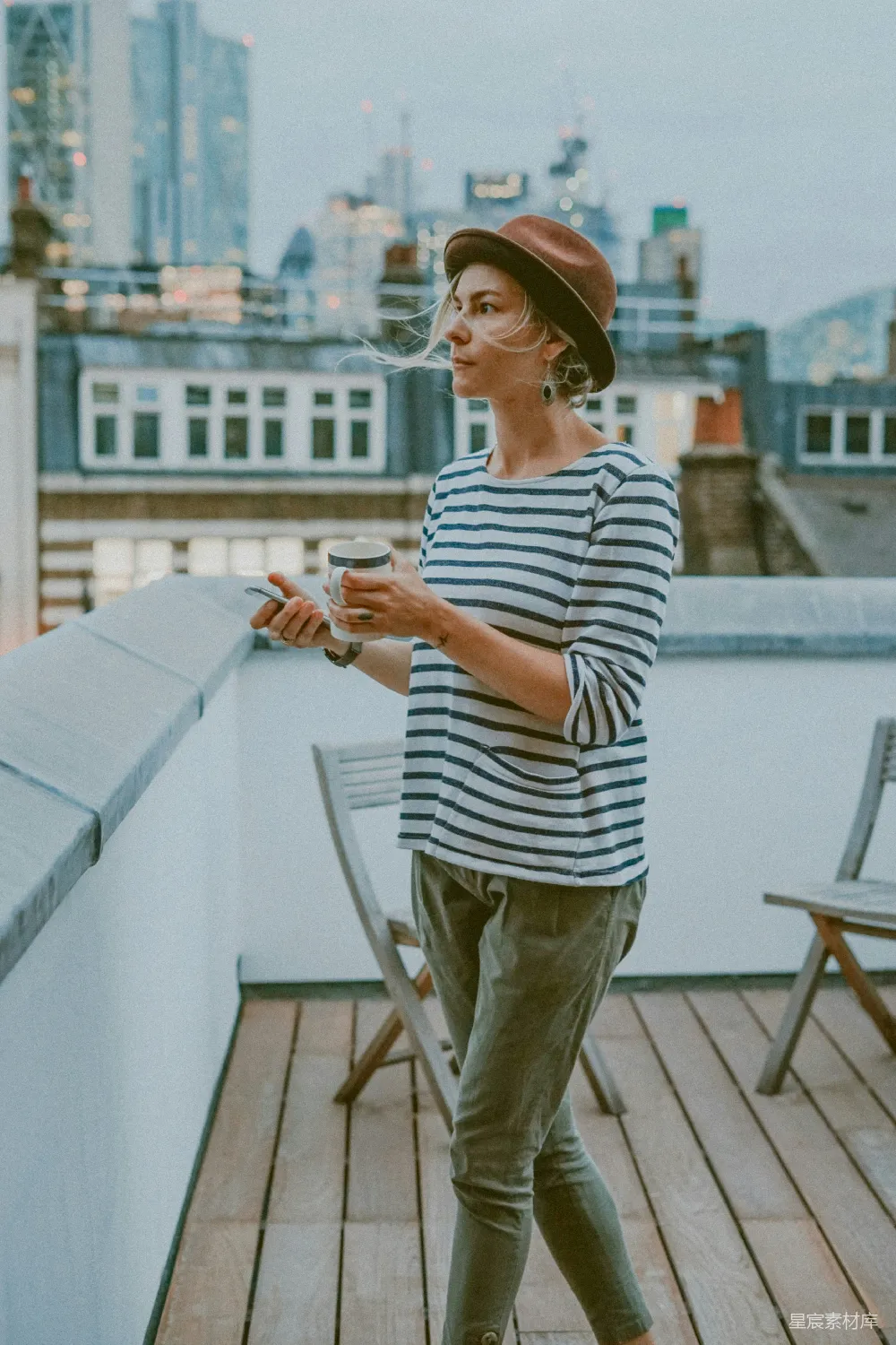 高清摄影 人物 白衬衫黑条纹上衣的女人正在拿着一杯。