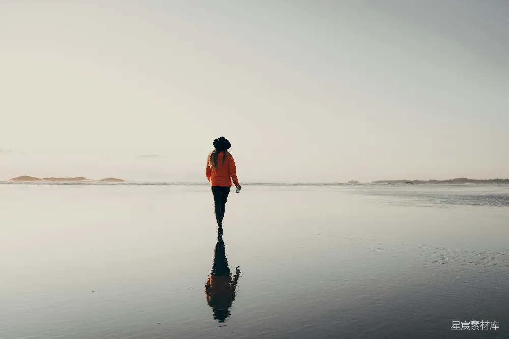 高清摄影 红色上衣的女人在海滩上行走