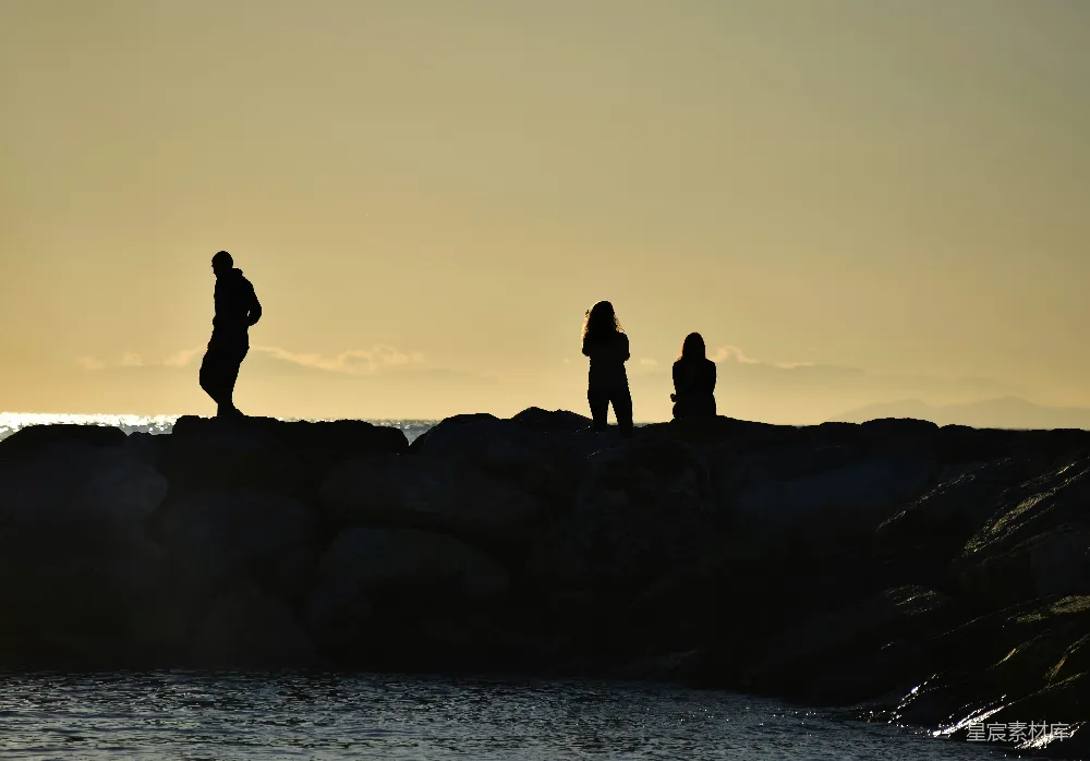 高清摄影 夕阳西下时，海边的轮廓人影
