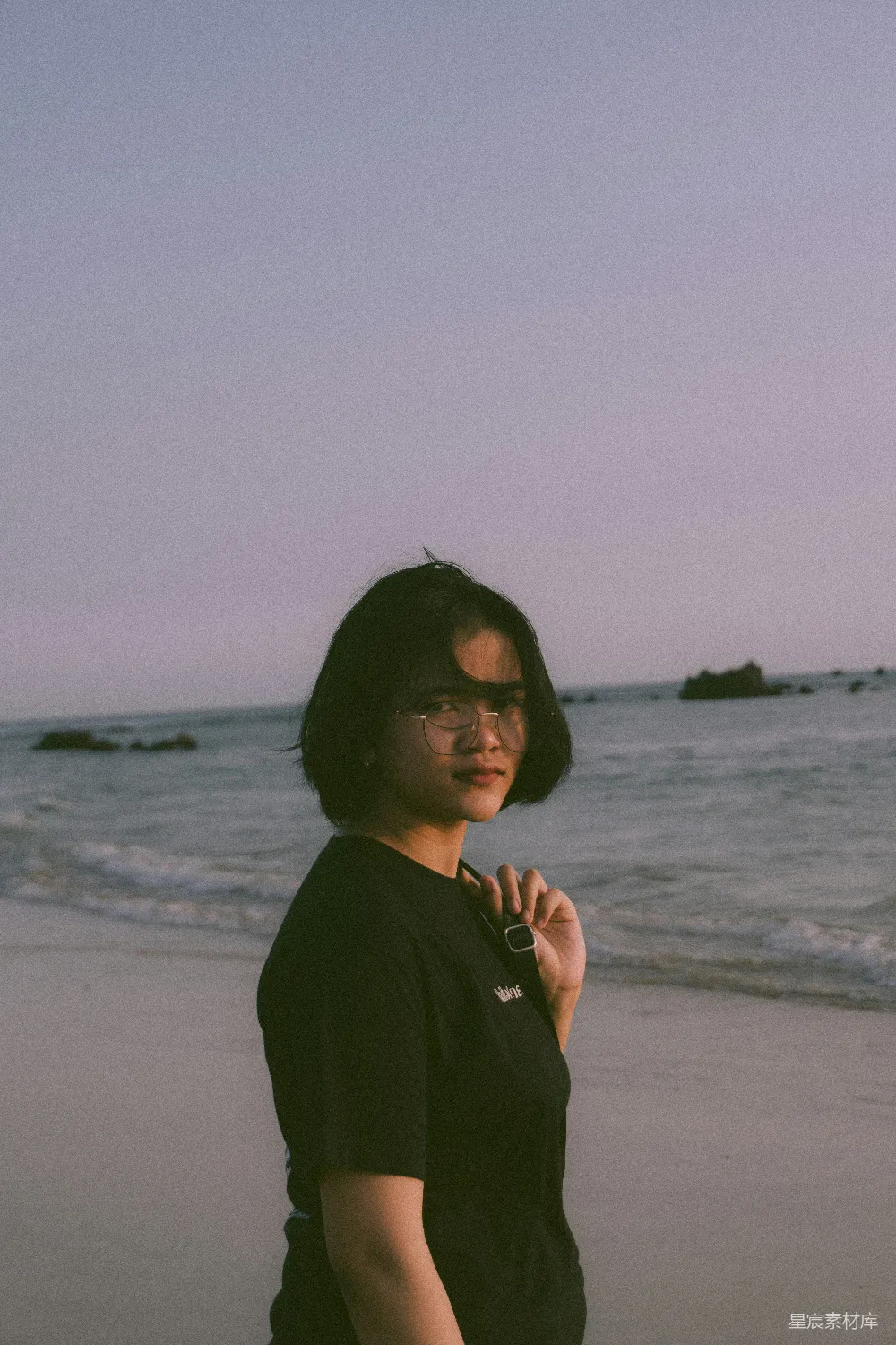 高清摄影 海滩上站着一位女性，旁边是海洋。