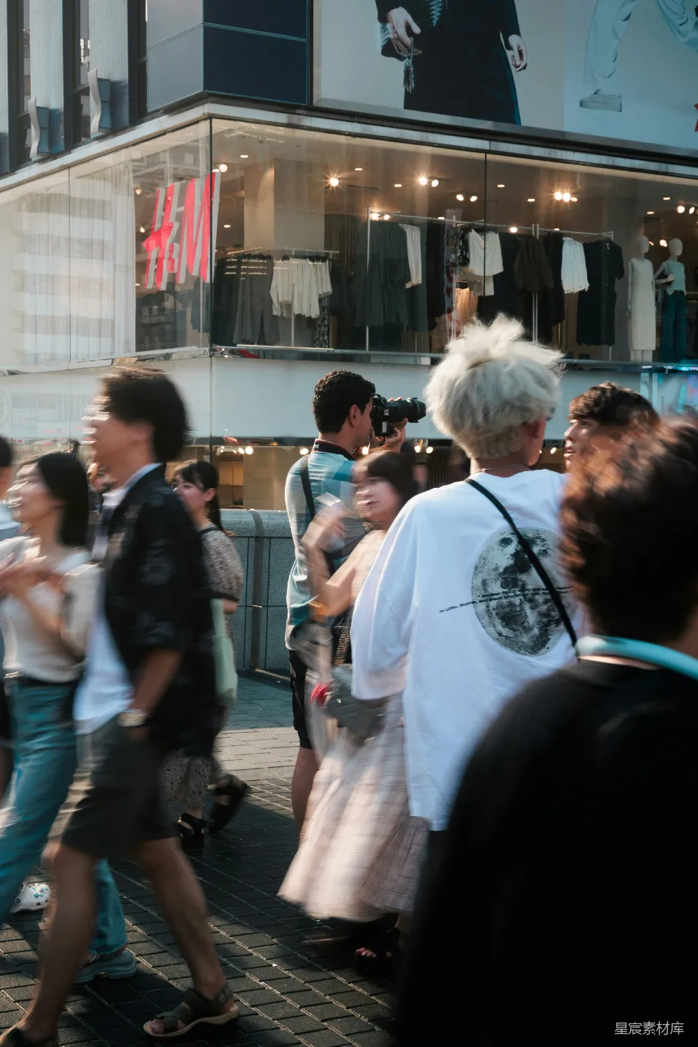 高清摄影  一群人在一座高楼上旁边的街道上行走