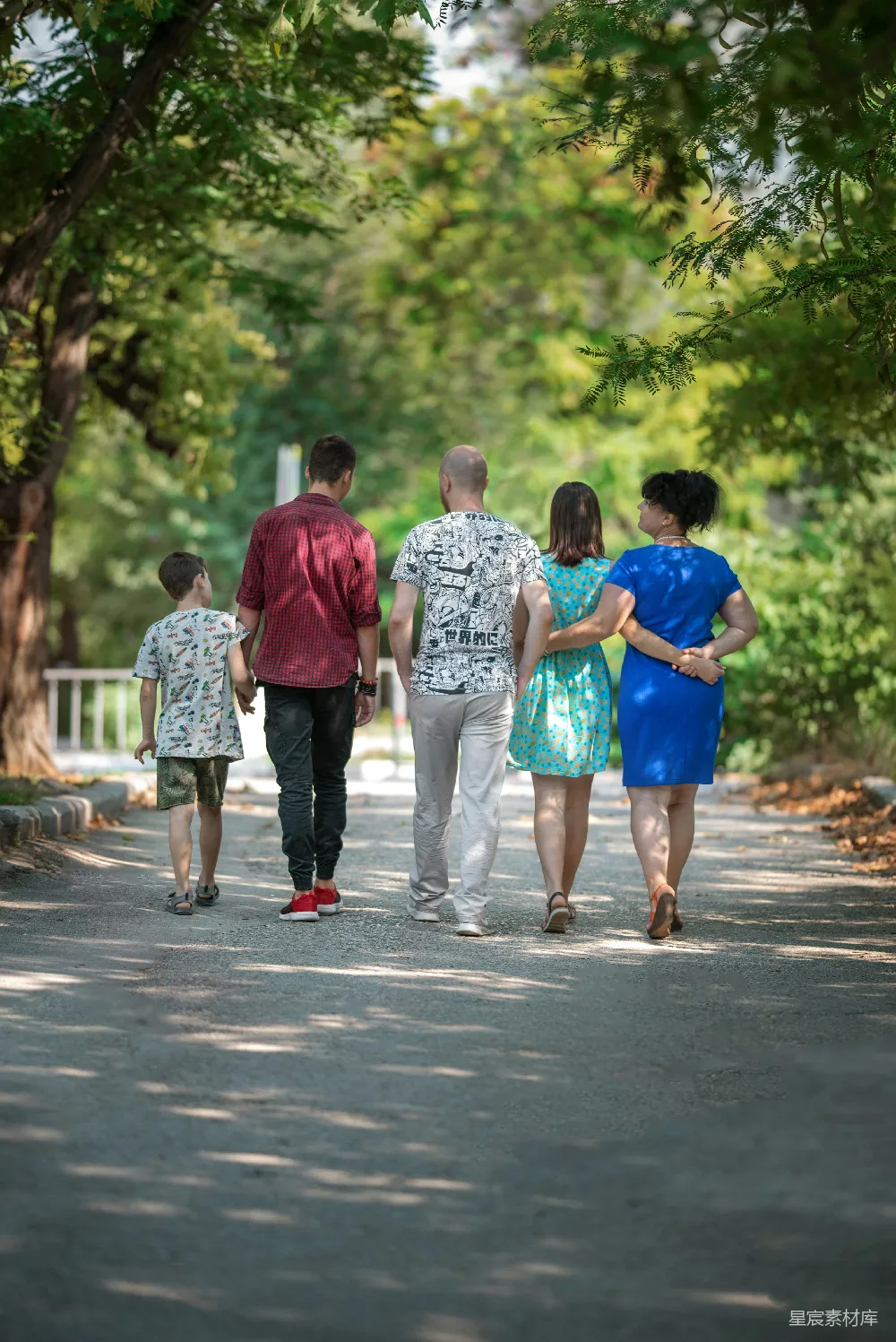 高清摄影 红色T恤和灰色裤子的男人牵着一个蓝色T恤的男孩的手