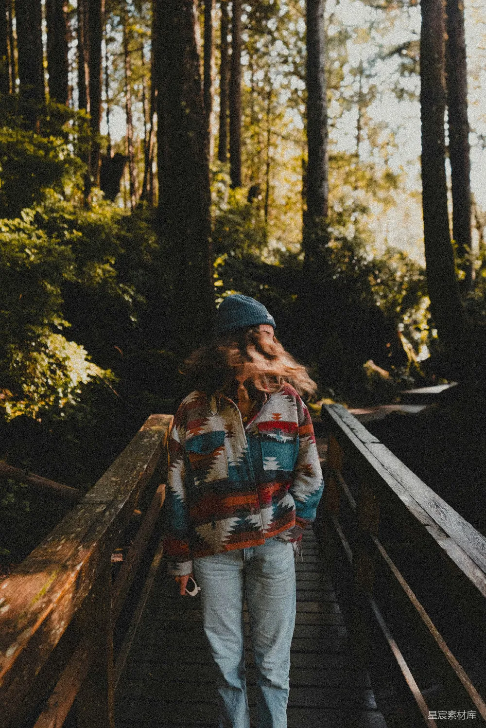 高清摄影 森林里一位妇女正在 wooden bridge 上行走。