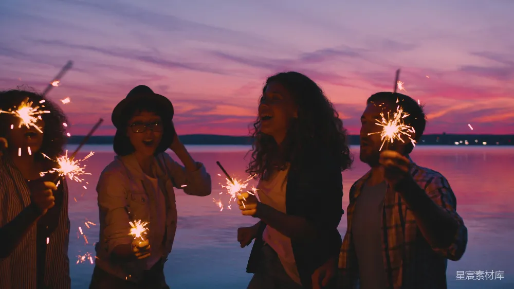 高清摄影  朋友在日落时分手持火花炮庆祝