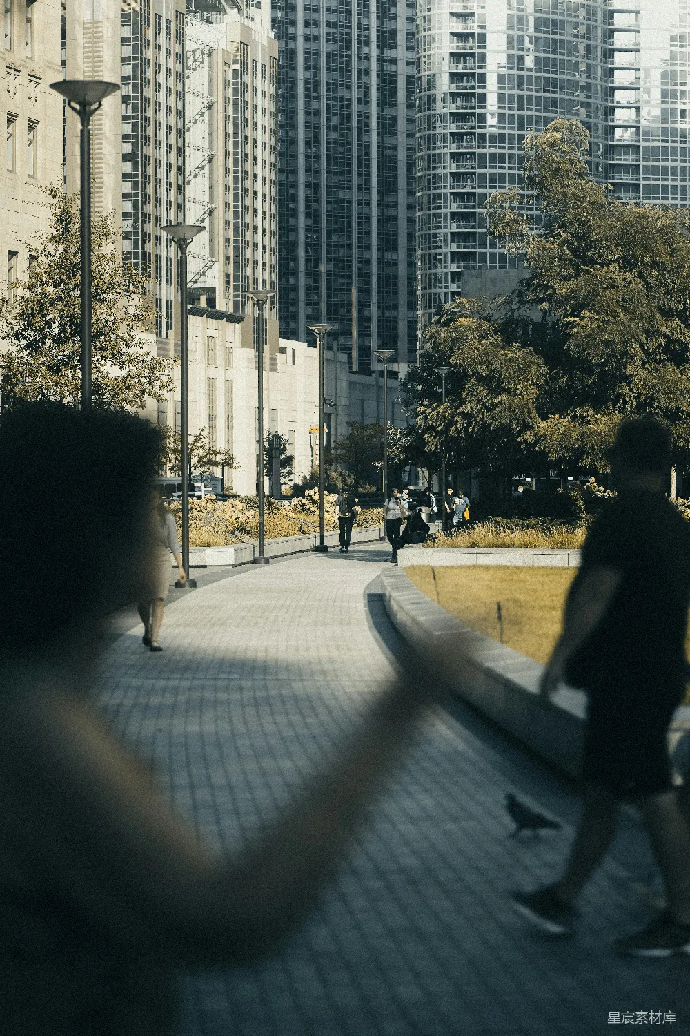 高清摄影 城市街道上人们行走，背后是建筑物。
