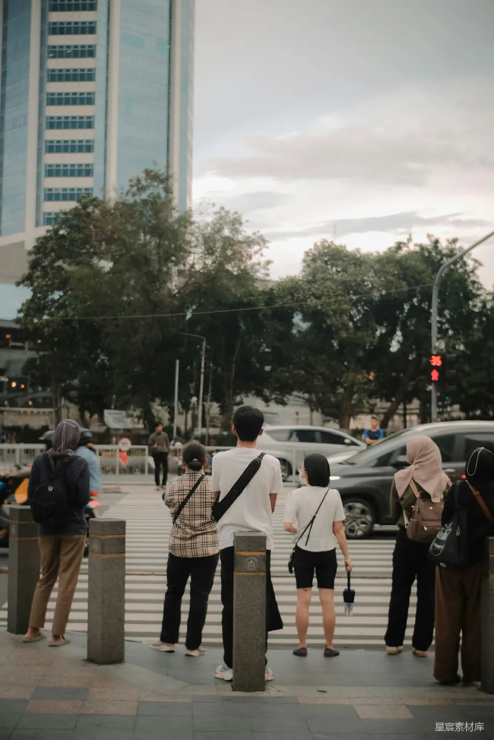 高清摄影  黄昏时分，人们在繁忙的城市街道上等待过马路。