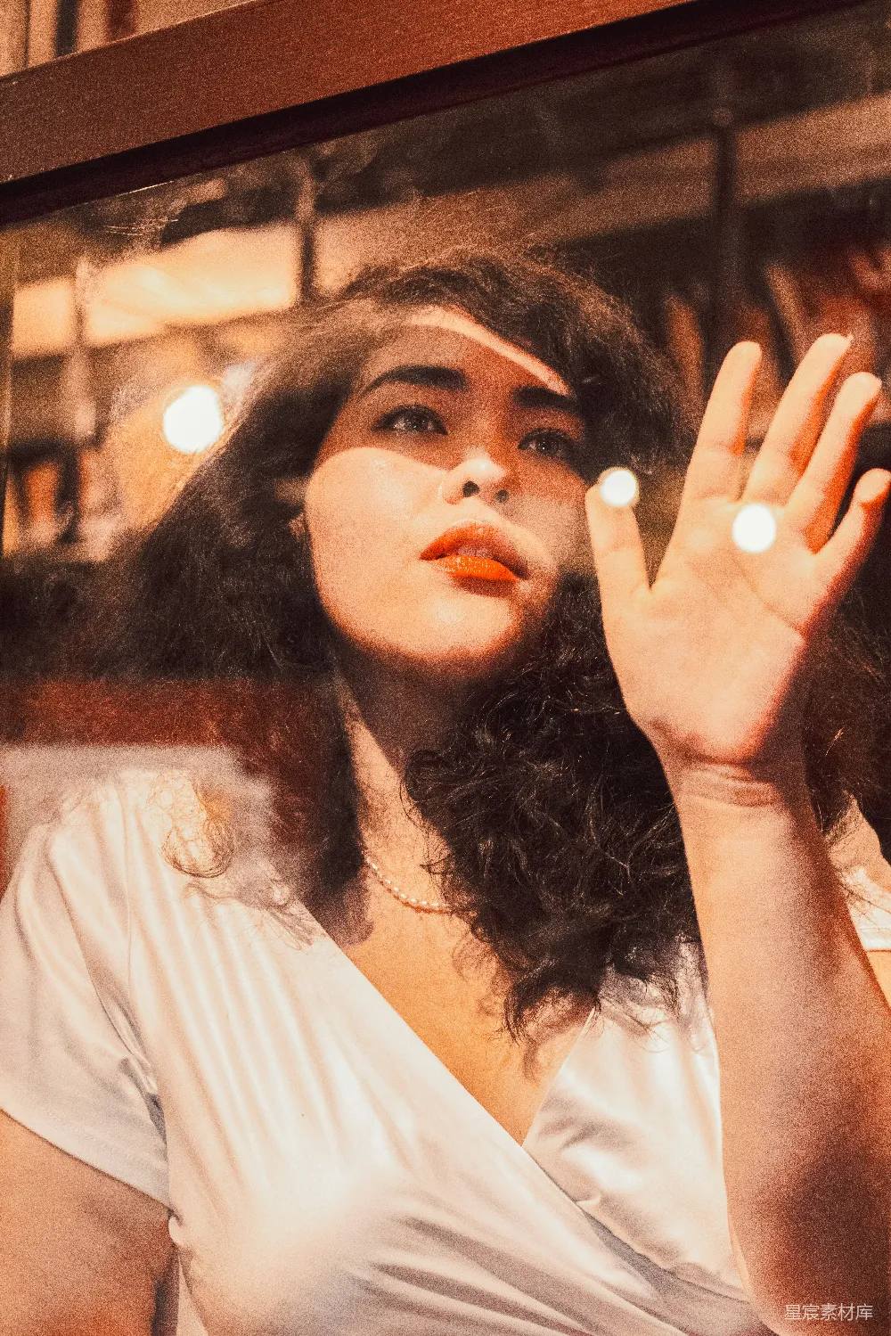 高清摄影 一个穿着白色上衣的妇女举着手臂