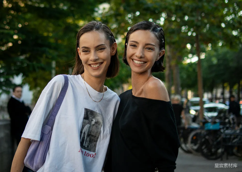 高清摄影 两名女子站在 sidewalk 上面彼此相邻。