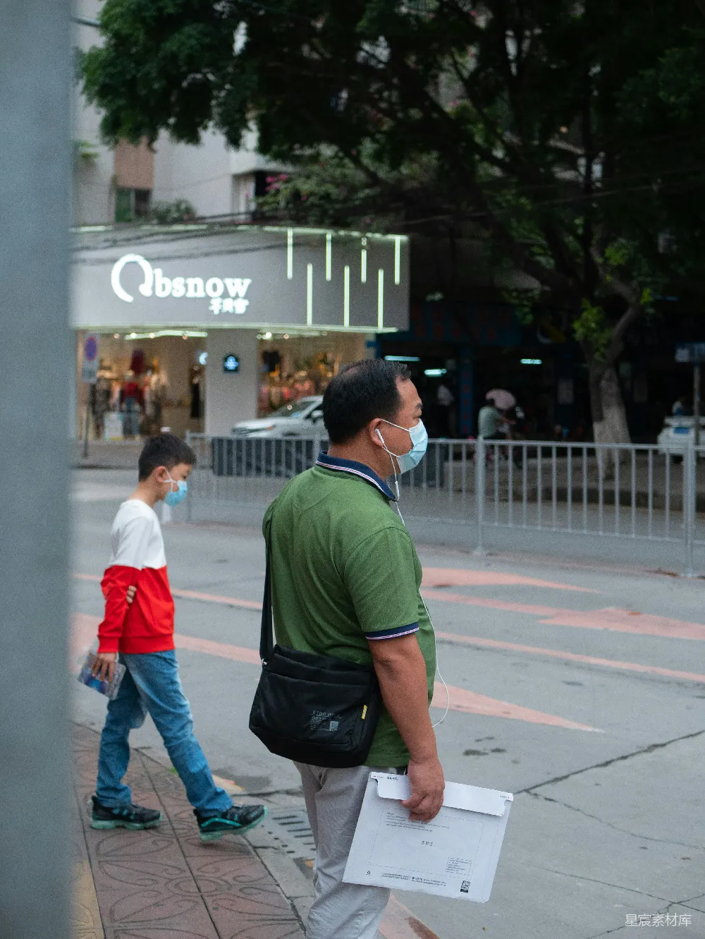 高清摄影 绿色上衣和蓝色牛仔裤的男人在白天街道上行走