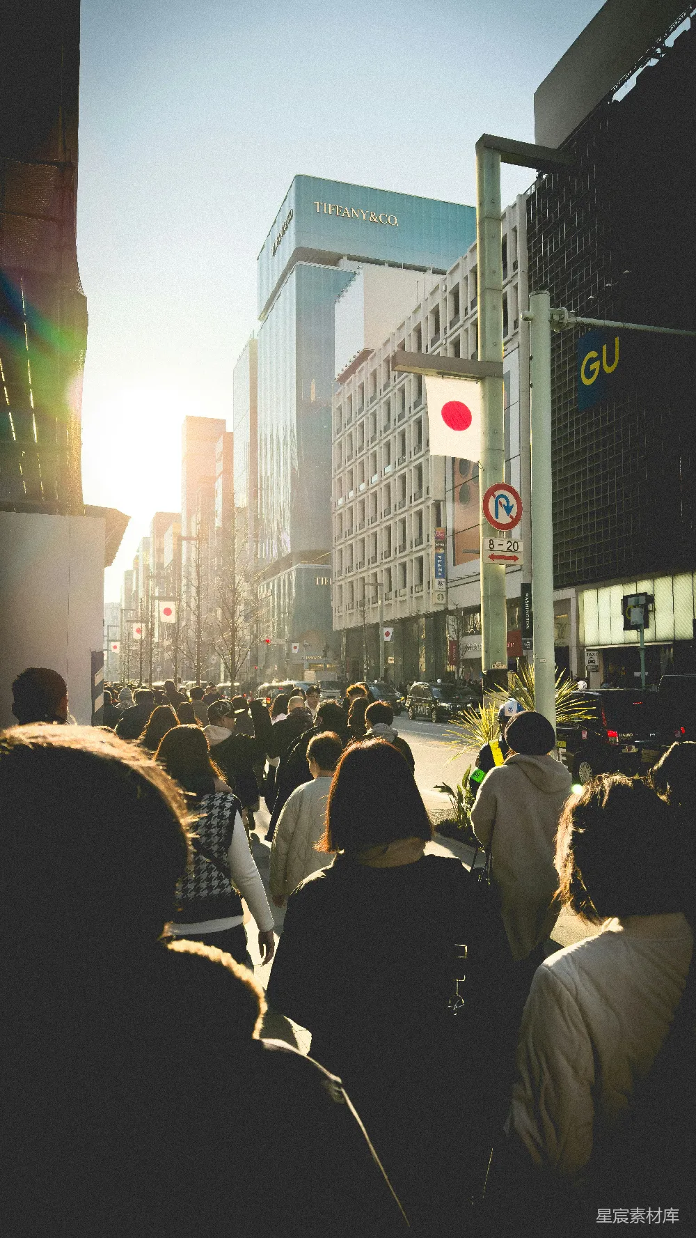 高清摄影 人们走在繁忙城市街道上，两侧是高大的建筑物。