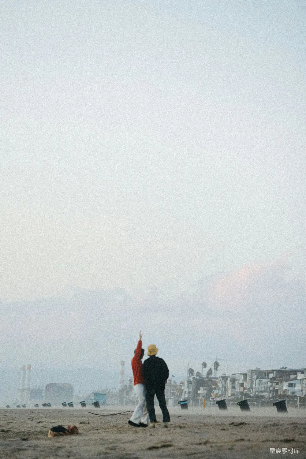 高清摄影  海滩上一位男士和一位女士放风筝