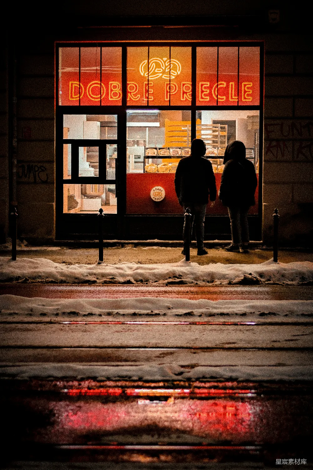 高清摄影  夜幕下两人在一家亮灯的脆皮店外