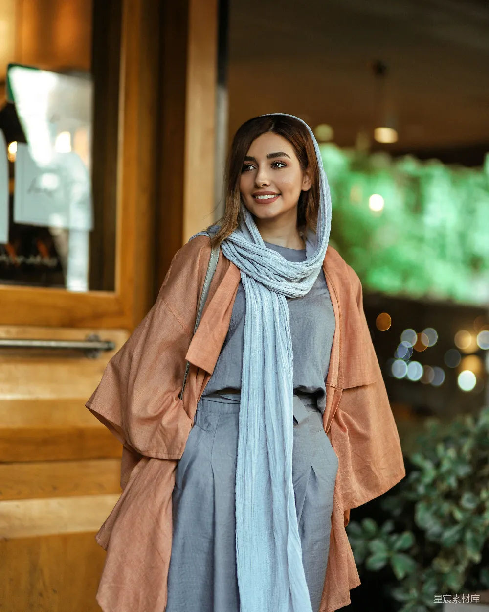 高清摄影 穿着棕色外套的女人站在棕色木墙旁边