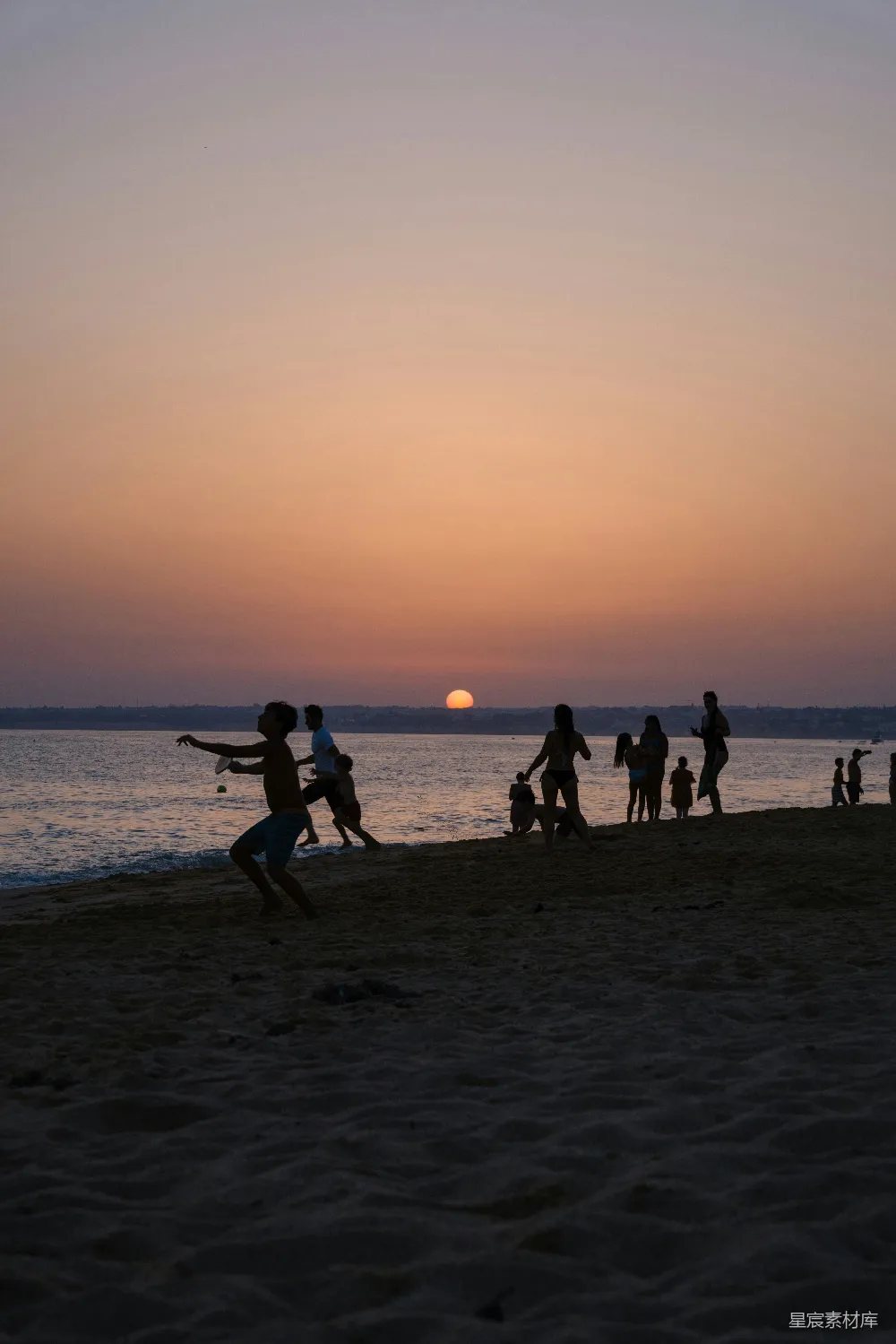 高清摄影 夕阳下人们享受海滩的轮廓